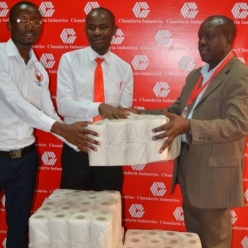 HR Manager Joash Mbulika hands over the bales of tissue to Joseph Ng&#039;anga, Director Heart of Passion Foundation
