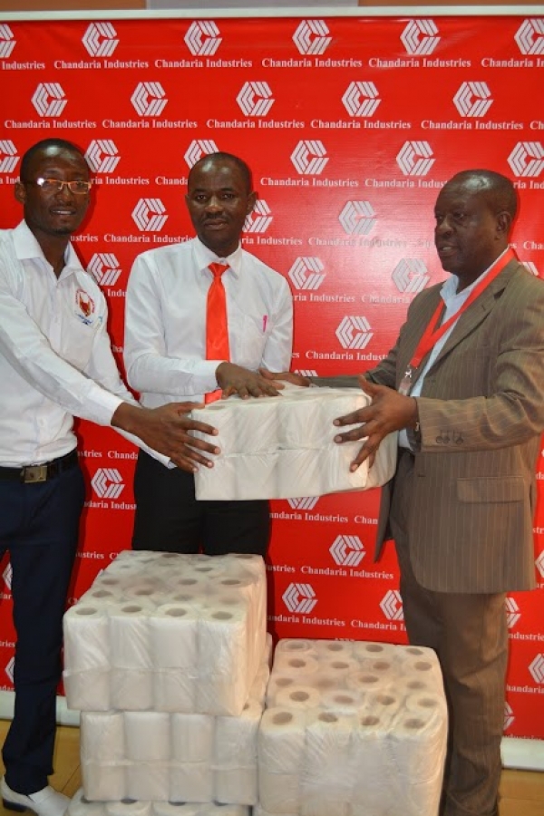 HR Manager Joash Mbulika hands over the bales of tissue to Joseph Ng&#039;anga, Director Heart of Passion Foundation
